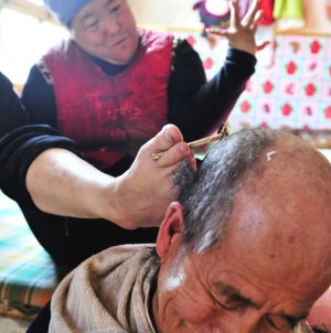 Disabled woman shaves her husband’s head using her feet