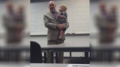 Professor holds little boy, continues teaching after single mom brings son to