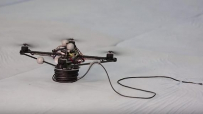 Watch as a trio of flying drones build a working rope bridge