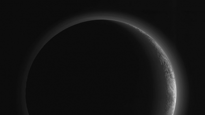 Pluto’s crescent shimmers in new NASA photo