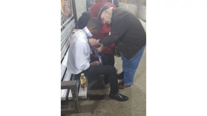 Elderly man gives stranger tie tutorial